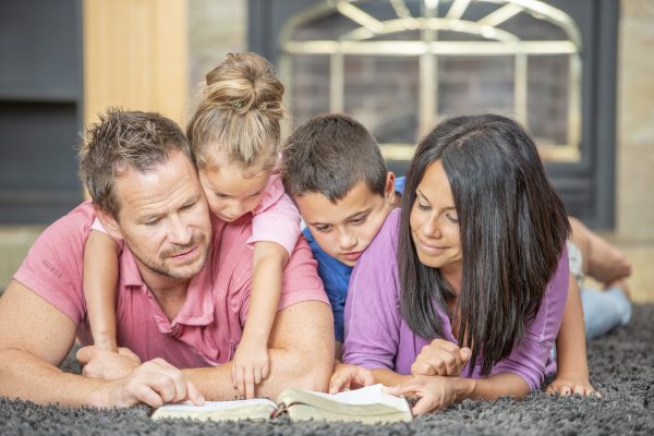 Young happy family embrace in the living room at home.